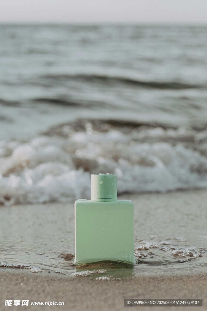 海邊沙灘上的綠色香水瓶