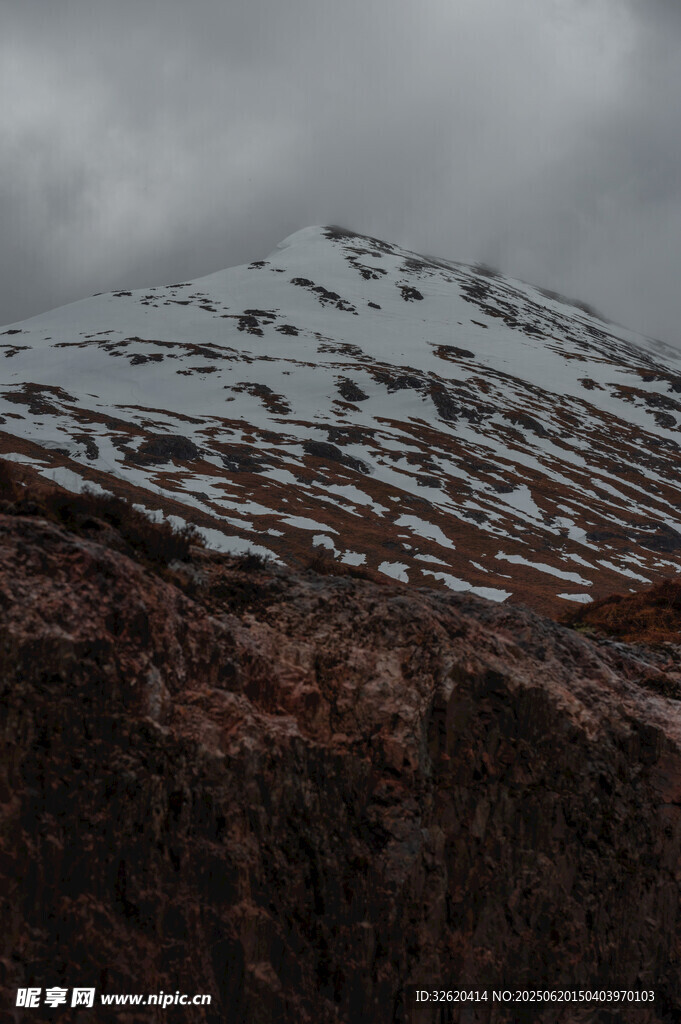雪山下的褐色山巒景觀
