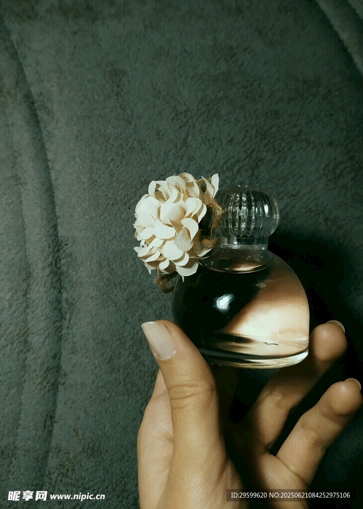 手持精致香水瓶飾花朵