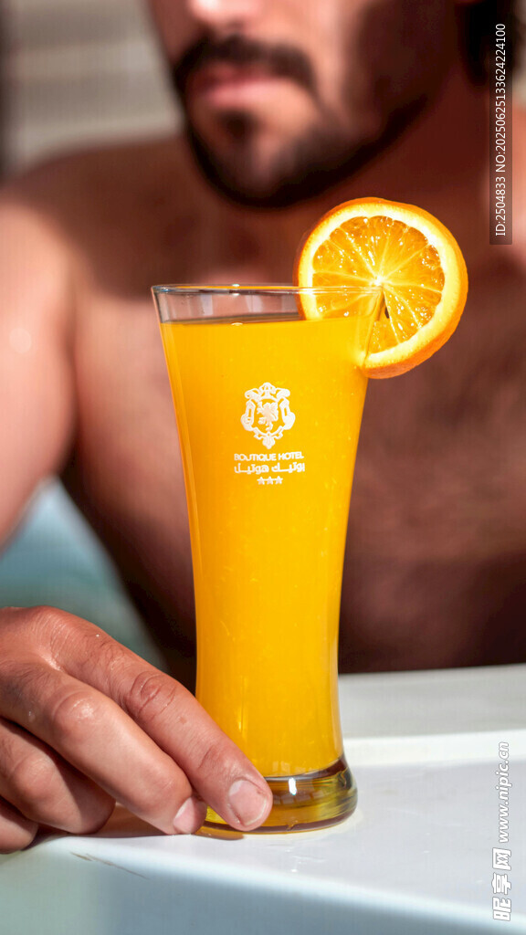 男士手持橙片裝飾的黃飲品