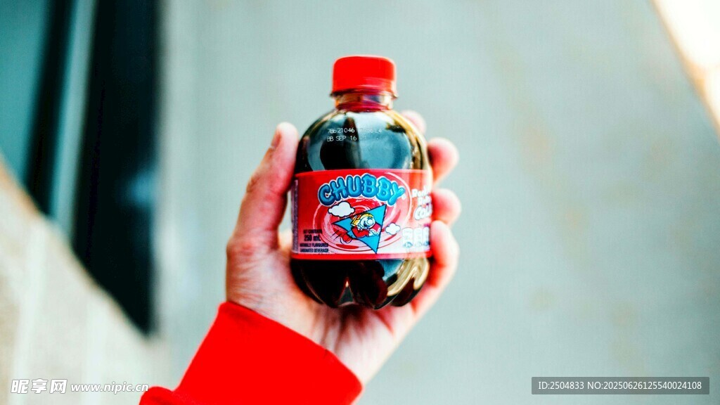 手握著的紅色瓶裝飲料
