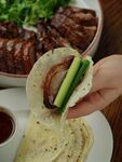手拿卷餅配美味烤肉