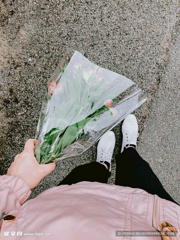 手持花束的粉色上衣身影