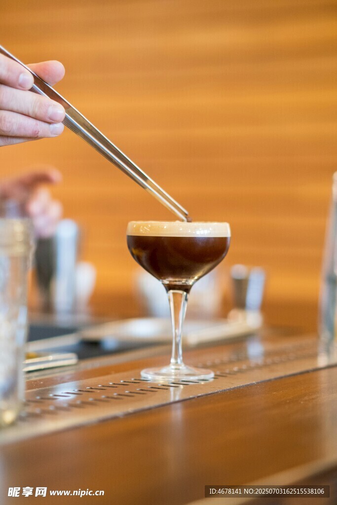 手用筷子攪拌高腳杯飲品