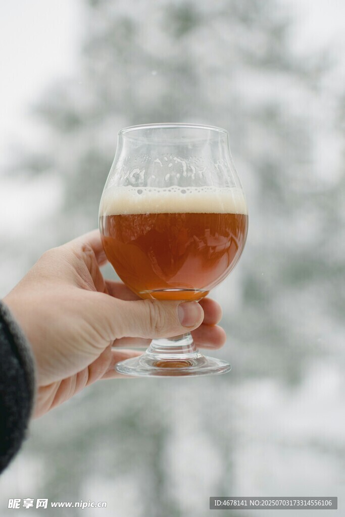手持精釀啤酒于雪景中
