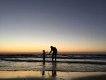 夕陽下海邊的親子時光