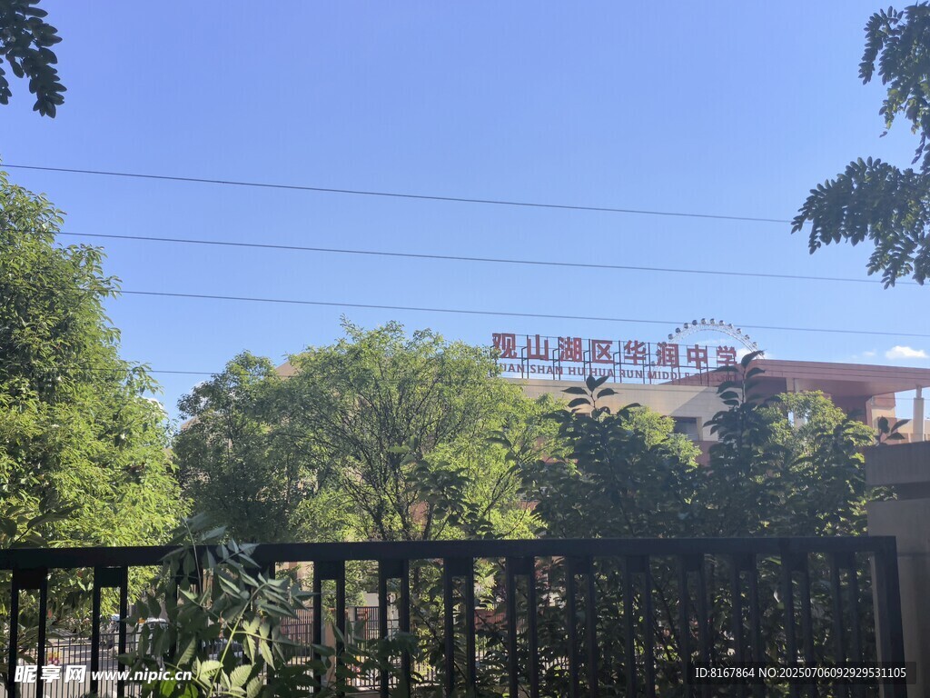 透過圍欄看綠樹與建筑