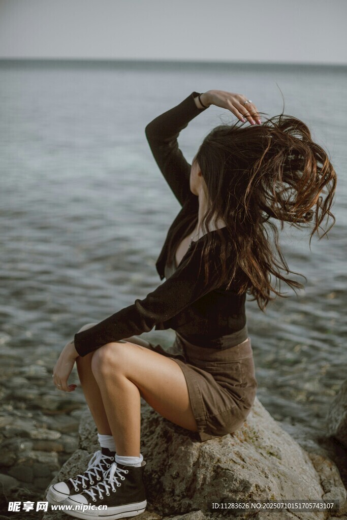 海邊巖石上的隨性女子