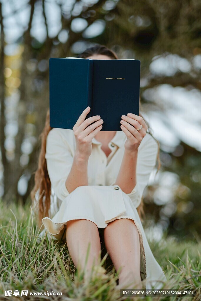 草地上專注讀書的小女孩