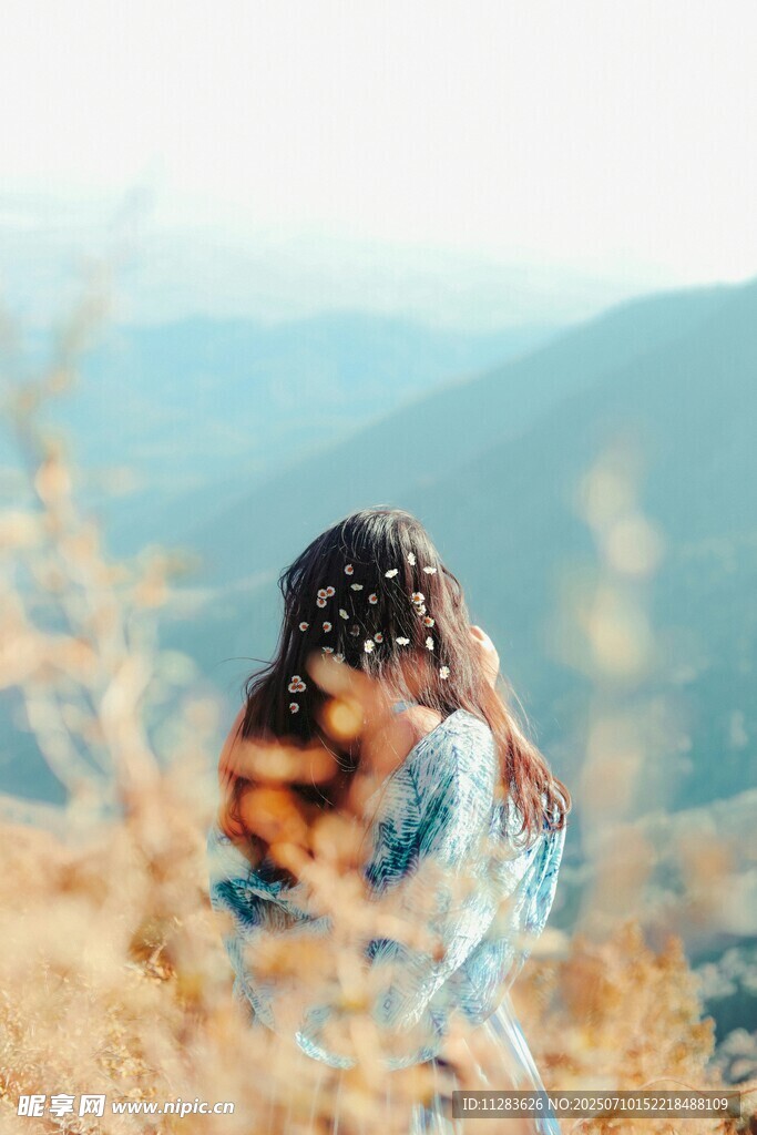 女孩于山間花海中靜立