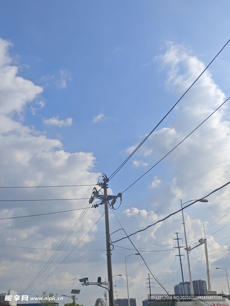 藍天白云下的電線桿景象