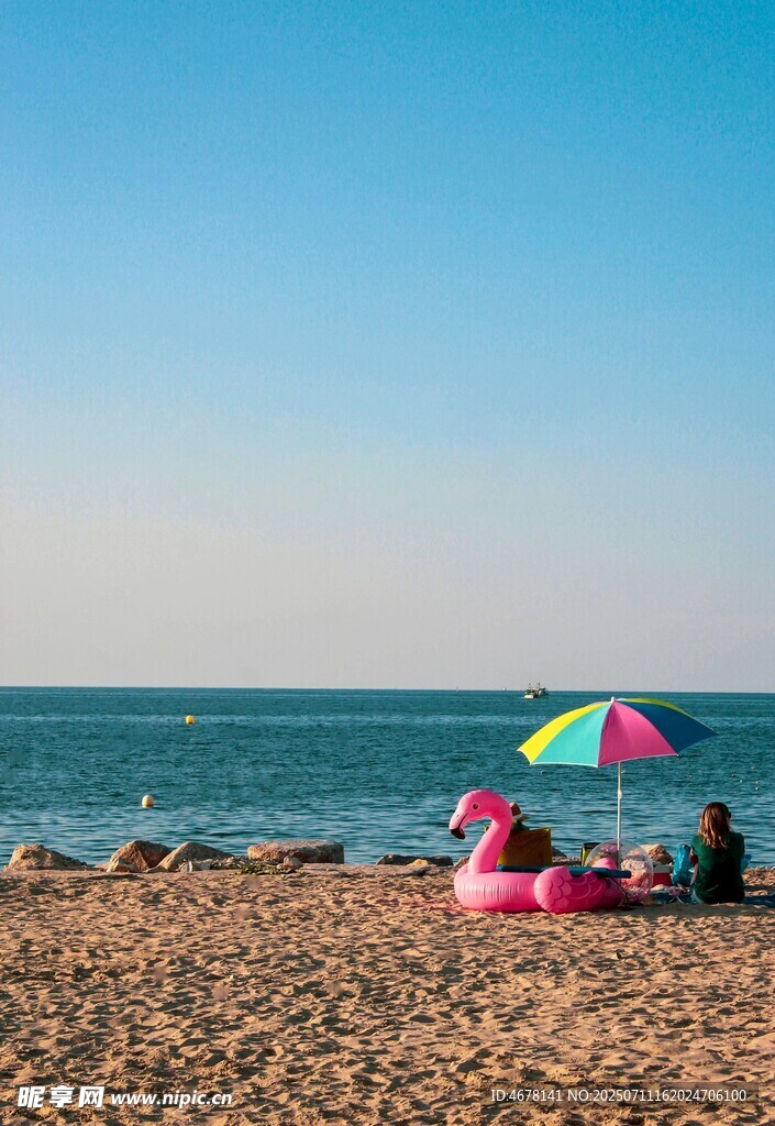 海灘上的彩色遮陽傘與休閑者