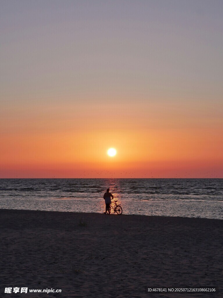 夕陽下的海邊漫步身影