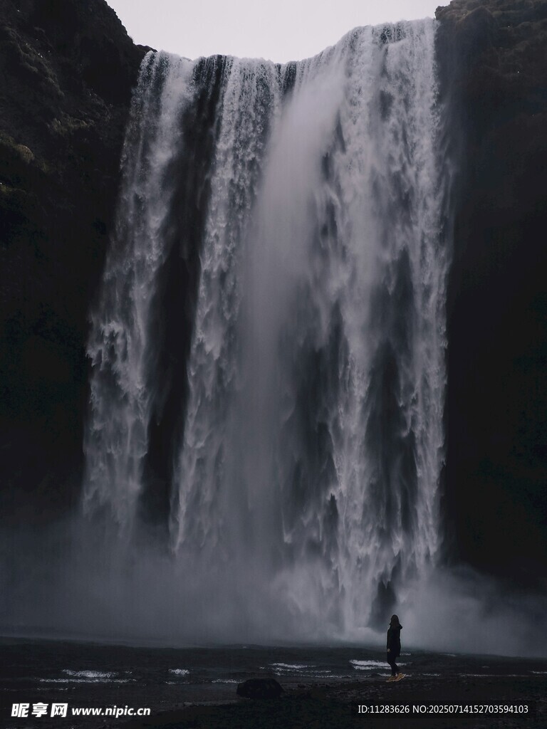 人立于壯觀瀑布前