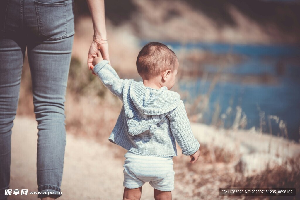 母親與幼兒牽手漫步戶(hù)外