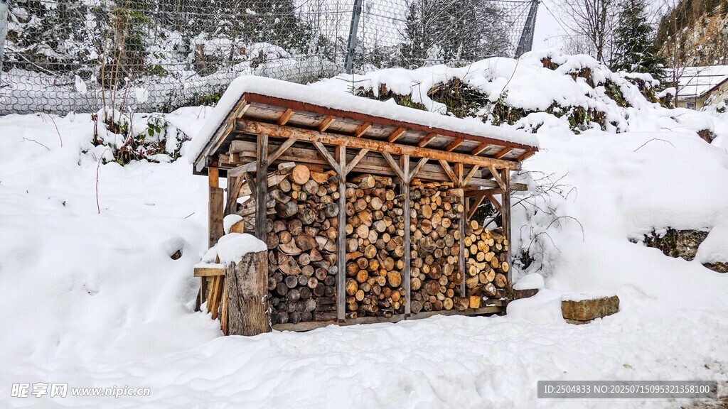 雪中小屋旁的木柴堆