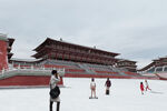 雪中古建筑前的游人身影