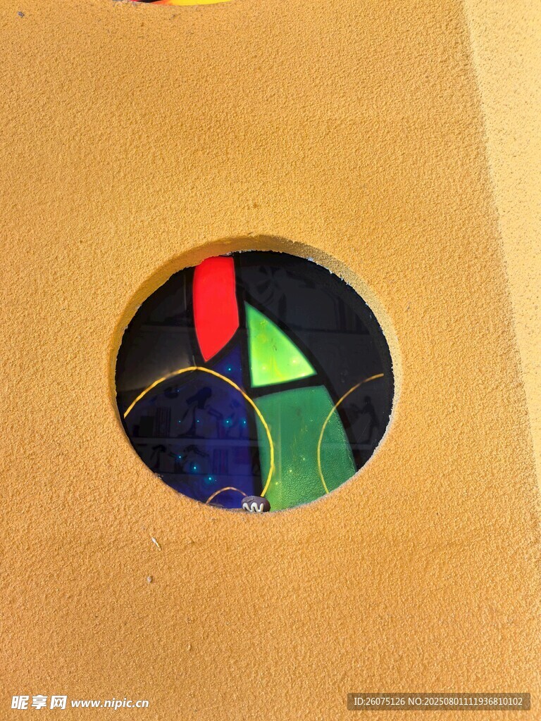 黃色墻面與圓孔中露出彩色物品