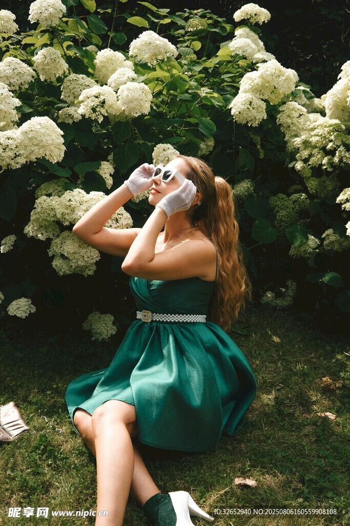 綠裙女子于花叢中愜意賞景