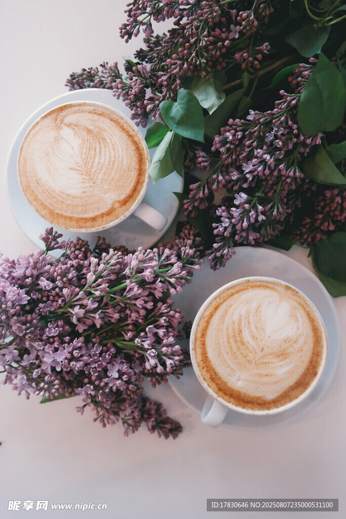 兩杯拉花咖啡與紫色花卉