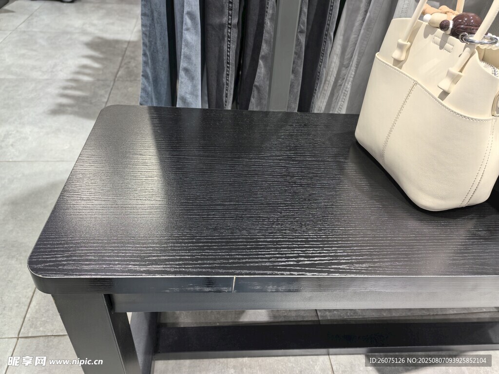 黑色凳子上的米色手提包