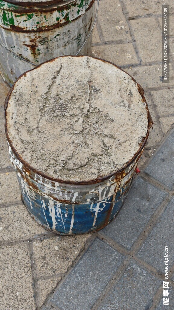 老舊鐵桶置于磚石地面