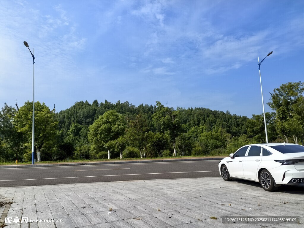 寬廣場(chǎng)地與公路旁的白色轎車