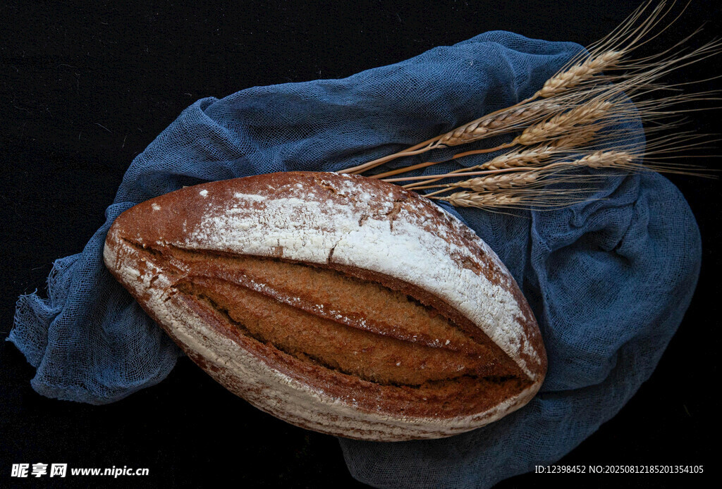 藍(lán)布上的全麥面包與麥穗