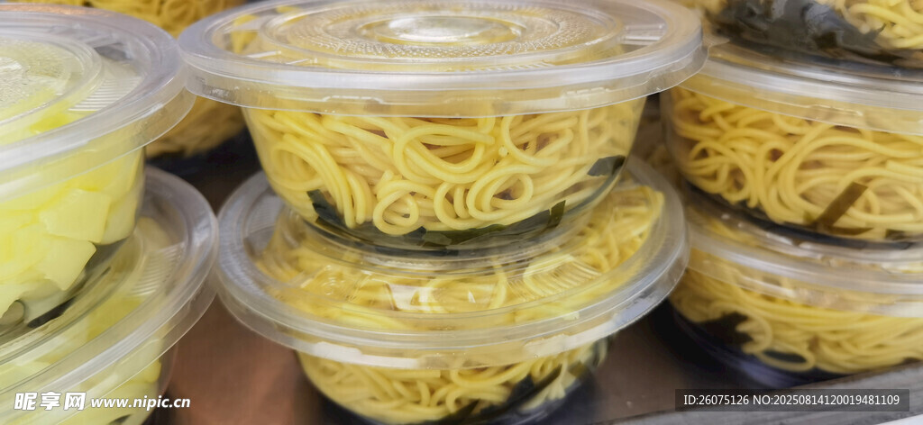堆疊的黃色塑料碗與涼面