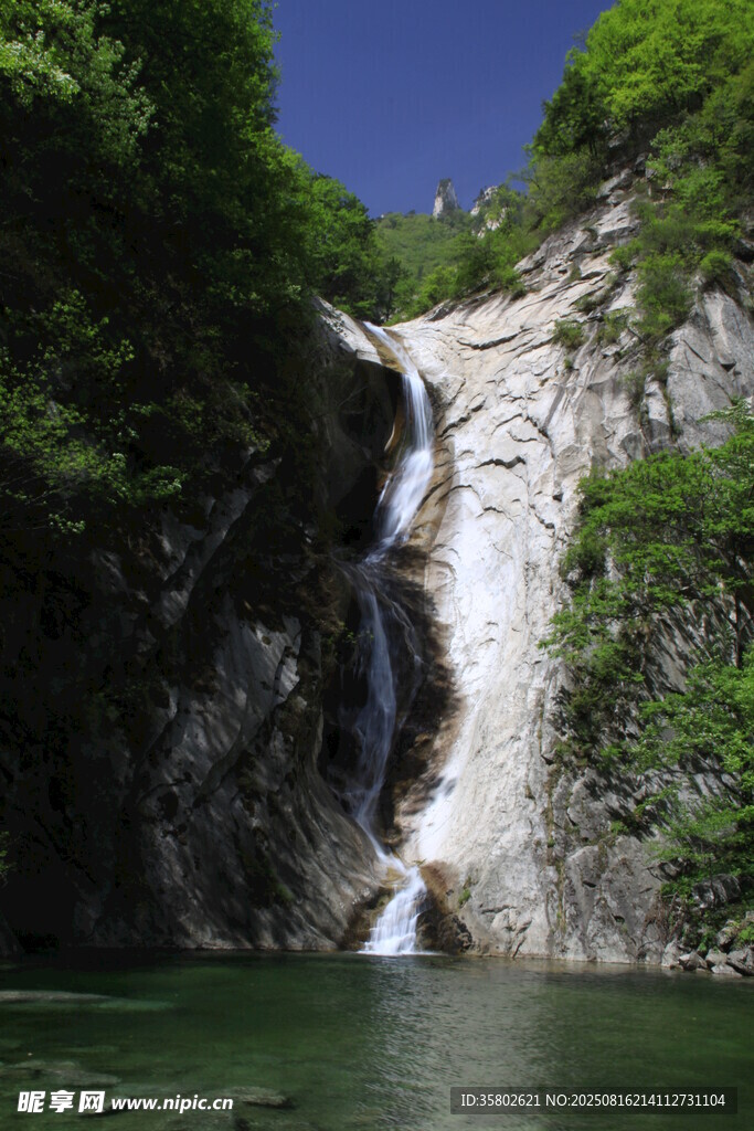 山間飛瀑下的碧綠潭水