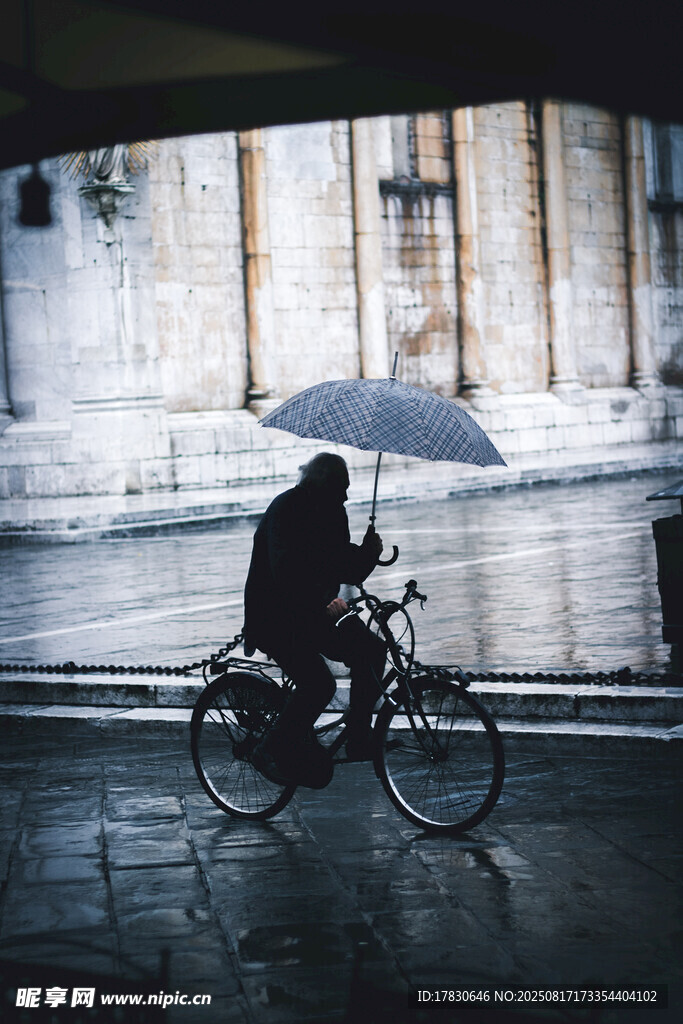 雨中騎車人撐傘前行