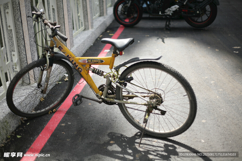 黃色自行車停靠在墻邊