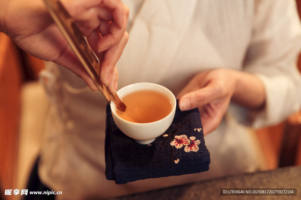 手持茶具品香茗