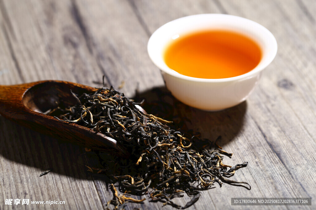 木桌旁的一杯香茗與茶葉