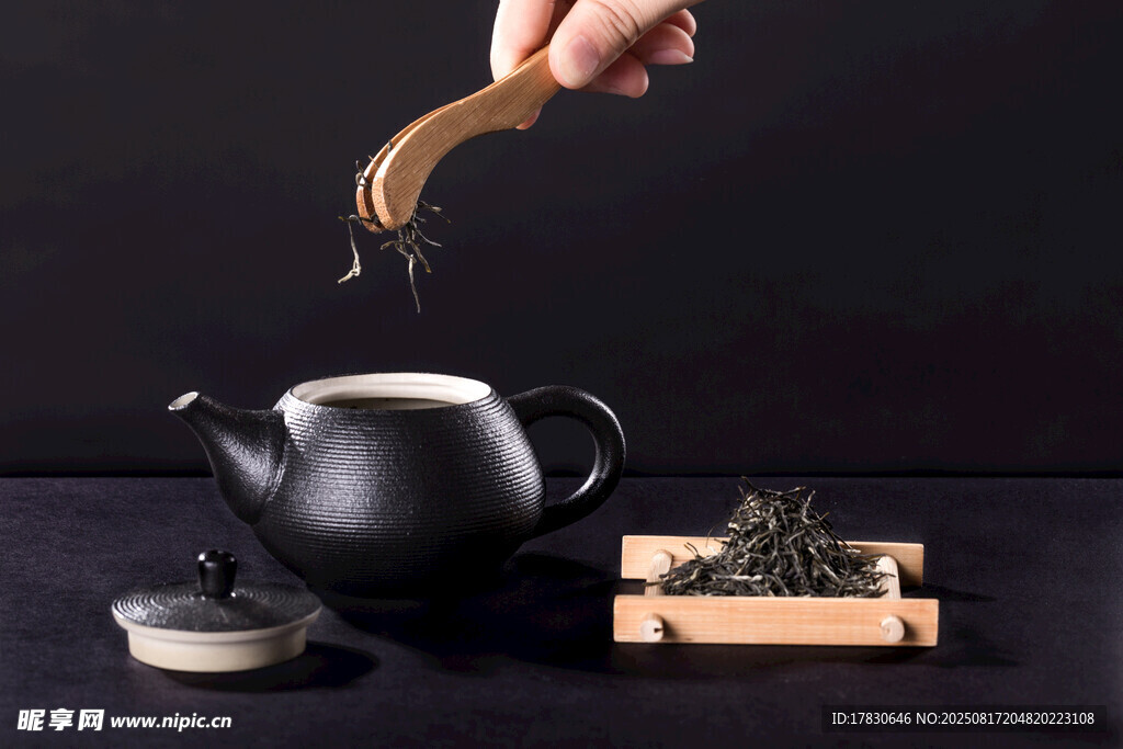 手添茶葉入古樸茶壺