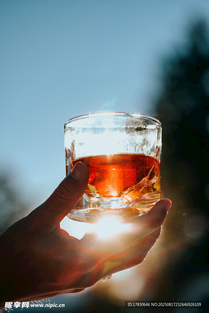 手捧琥珀色液體的玻璃杯