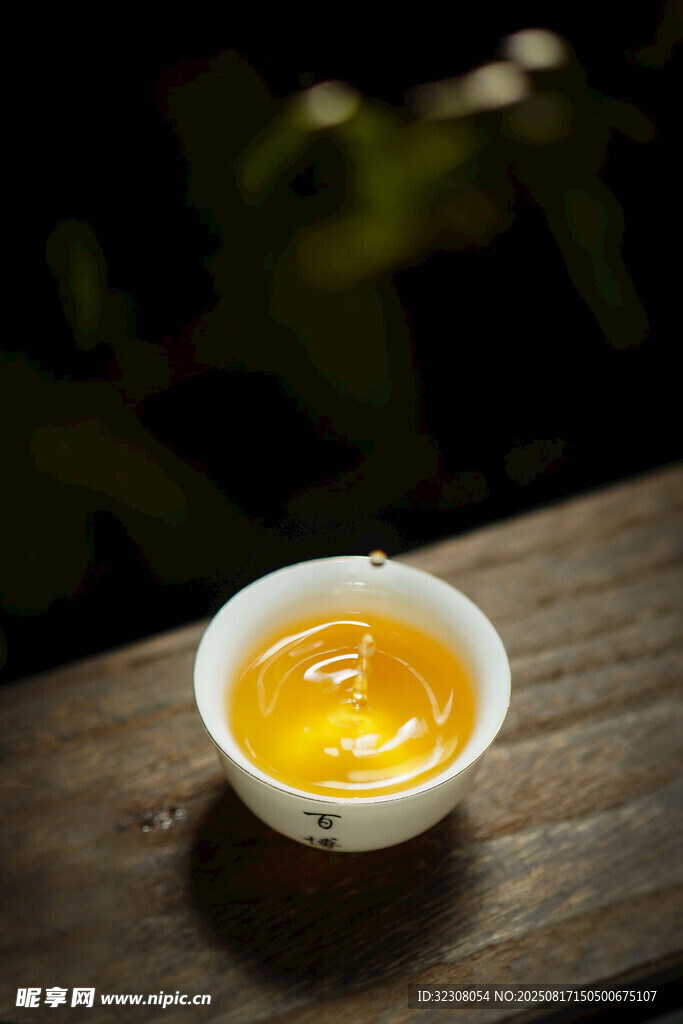 木桌上的一盞金黃茶湯