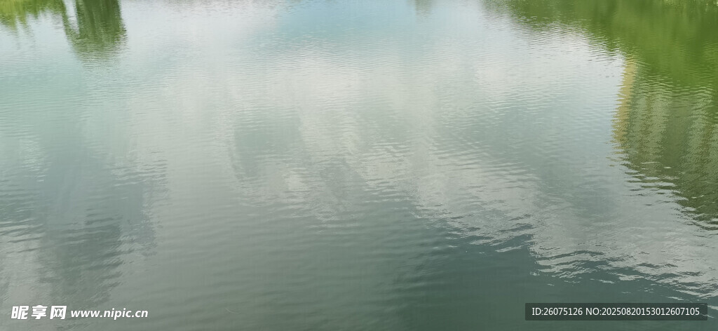 云與綠植的湖面倒影景致