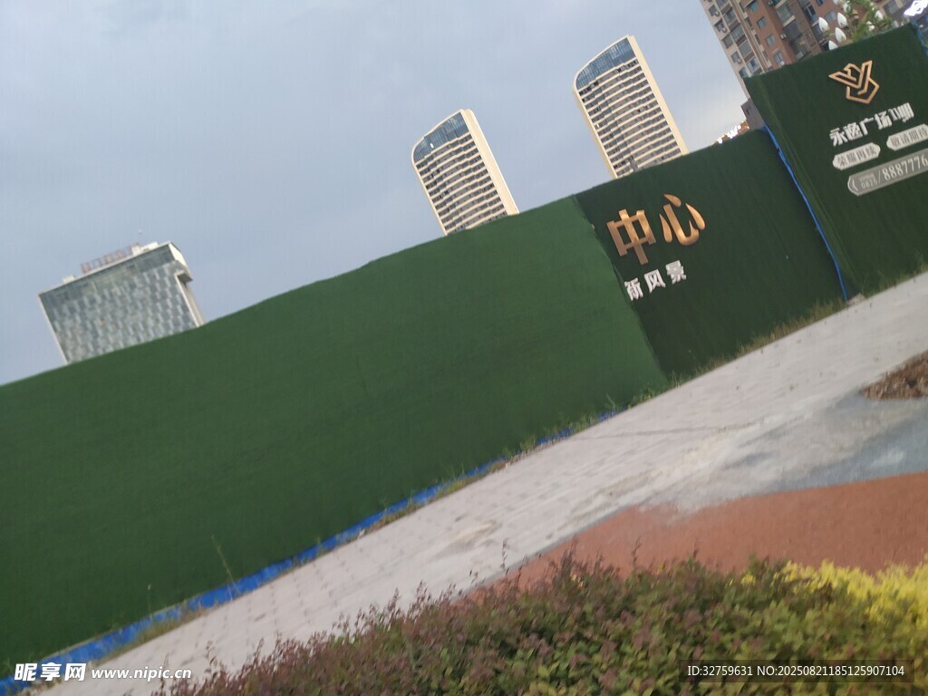 綠色圍擋旁的城市建筑景觀