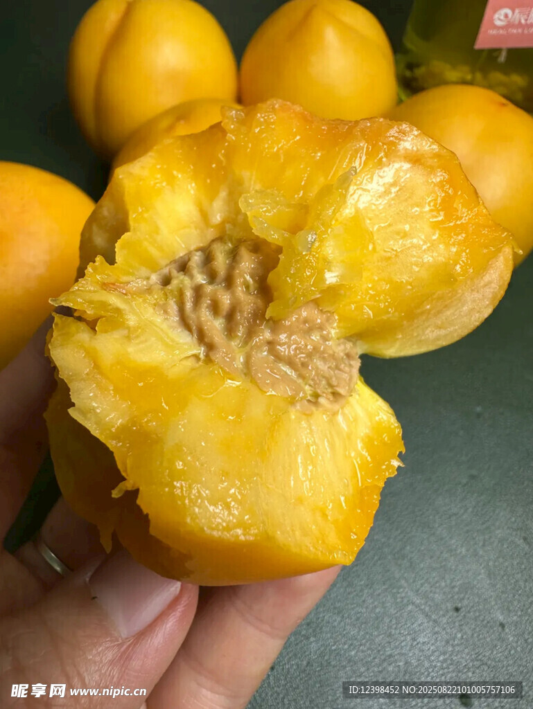 手捧掰開的金黃多汁黃桃