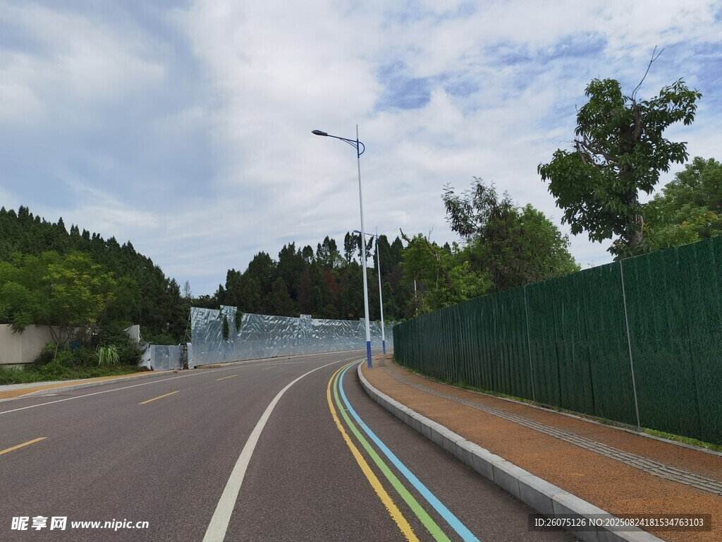 寬闊公路旁的綠色圍欄景觀