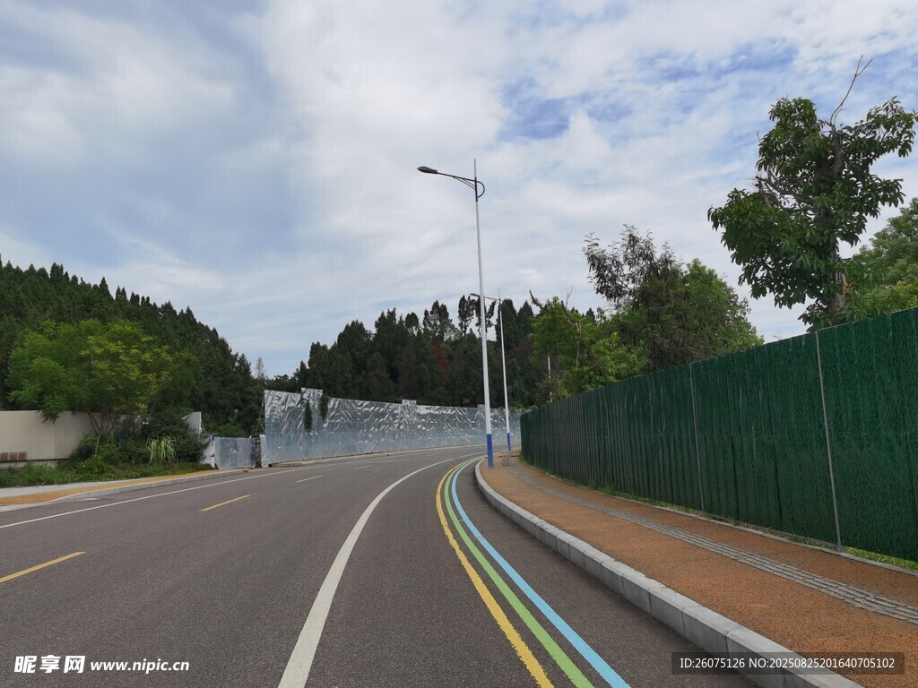 寬闊道路旁的綠色圍欄景觀