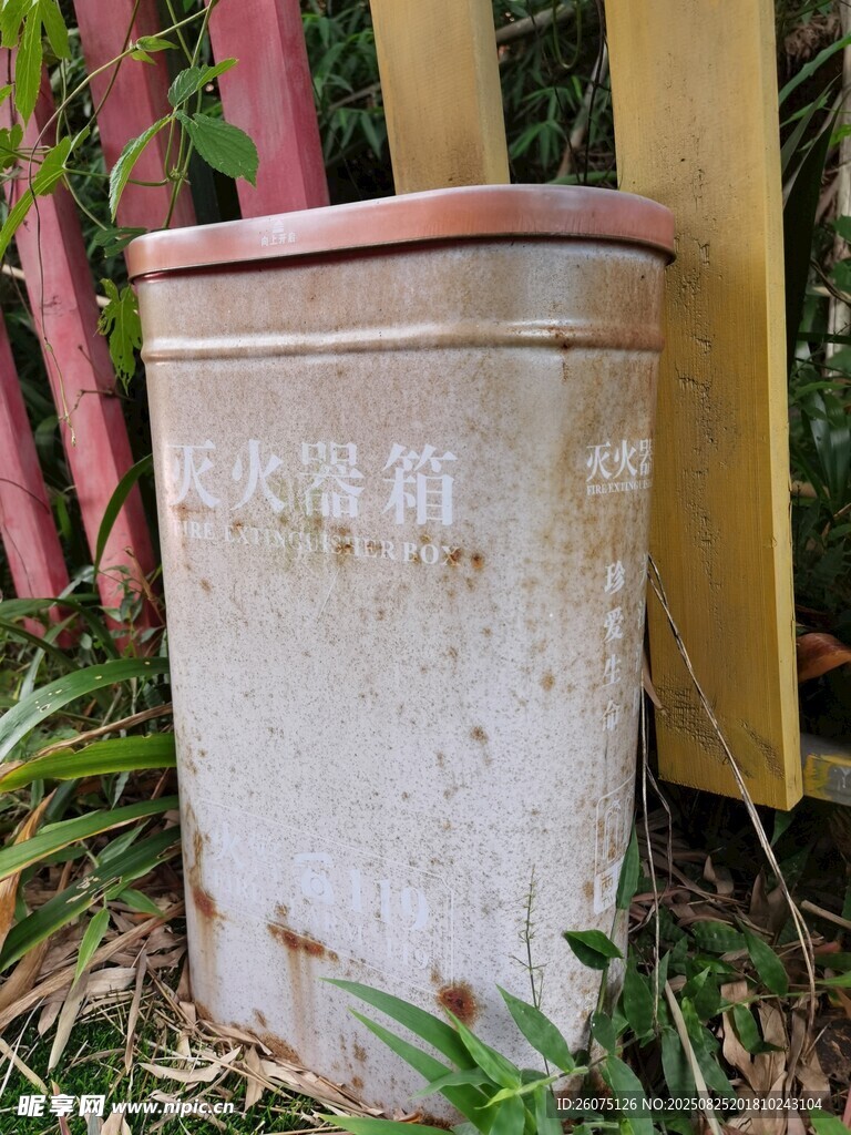 老舊滅火器材置于草叢旁