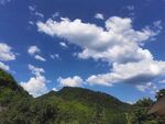 藍(lán)天白云下的蔥郁山巒