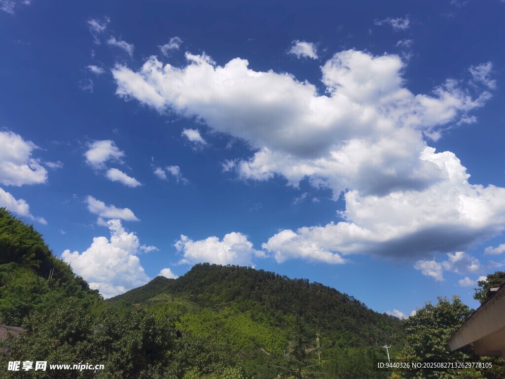 藍(lán)天白云下的蔥郁山巒