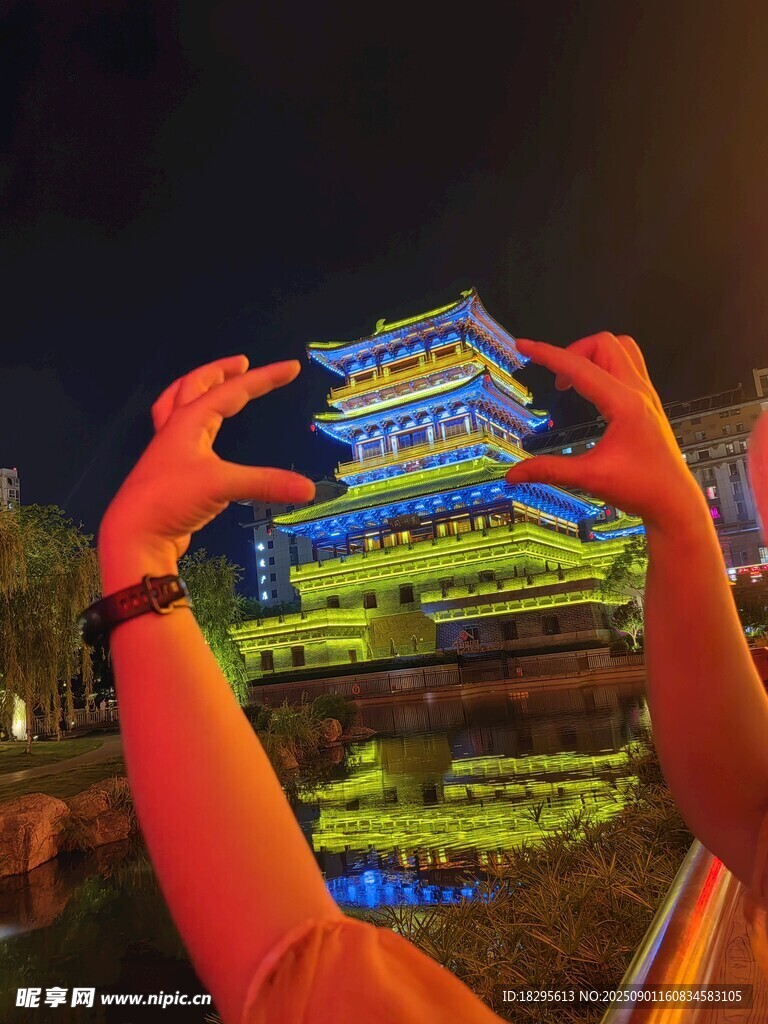 雙手框景下的璀璨建筑夜景