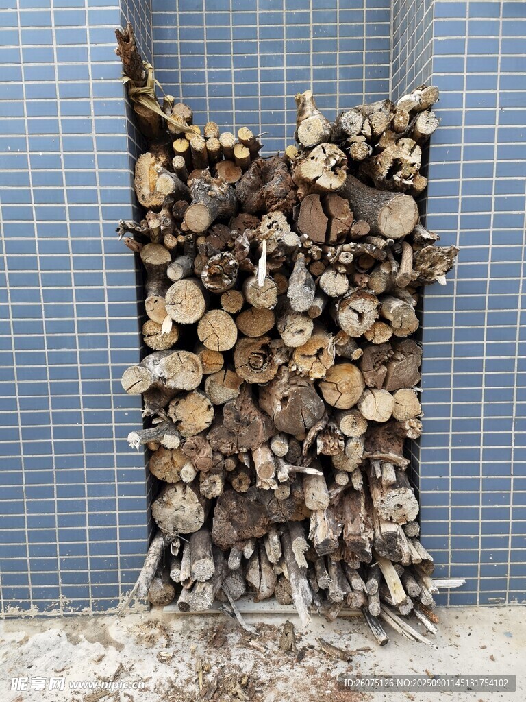 灰色墻縫中整齊堆放的戶外木柴