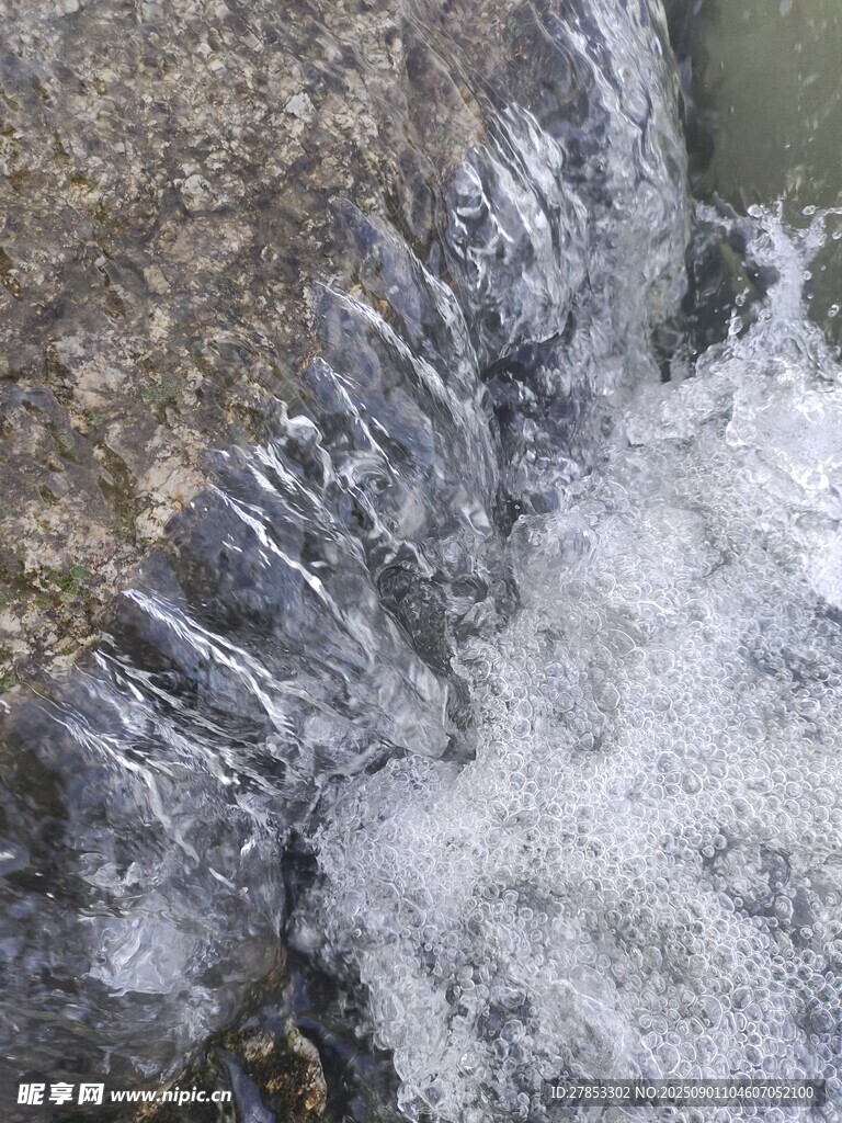 流水擊石濺起白色水花