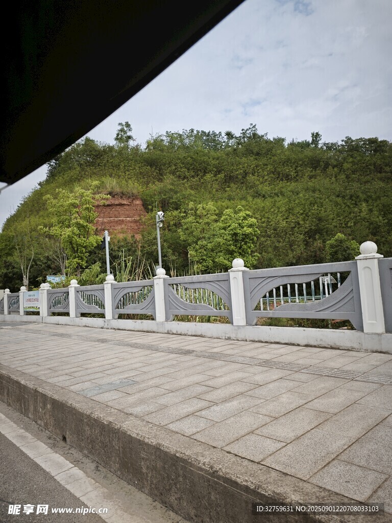 路邊白色圍欄與青山景色