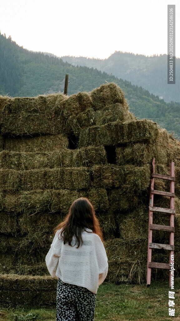 女子眺望草垛與遠(yuǎn)山